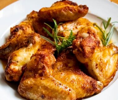 Golden-brown chicken wings garnished with fresh herbs, perfect for a tasty meal.
